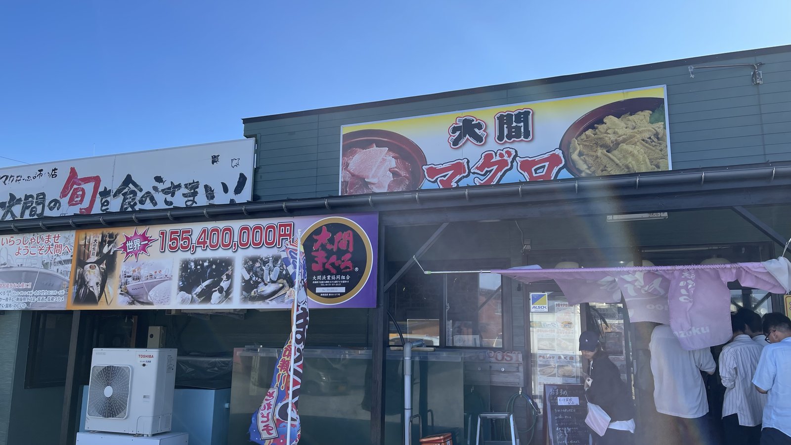 「大間マグロ」の看板が掲げられた食堂「魚喰いの大間んぞく」の外観