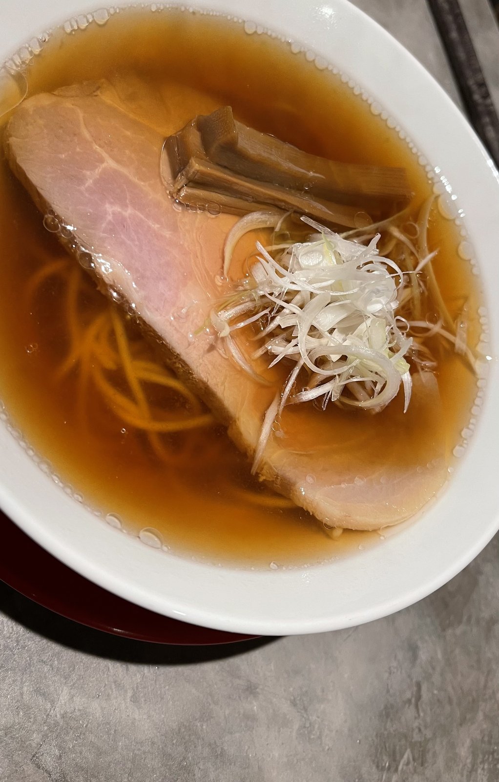 チャーシューとメンマ、白髪ねぎがのった澄んだ醤油ラーメン